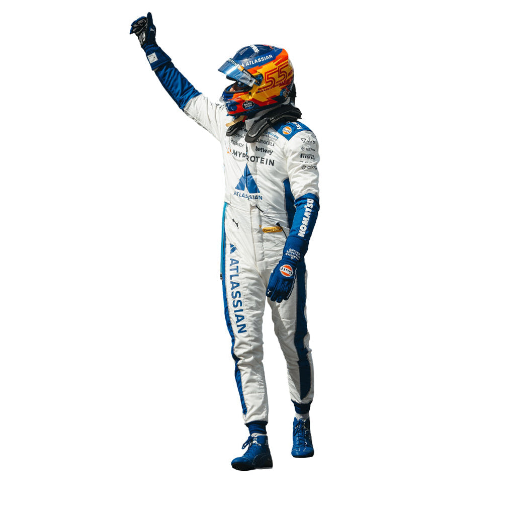 F1 driver Carlos Sainz  in a white 2025 United States GP F1 Racing Suit with blue and orange accents, raising his right hand. Speedxgear